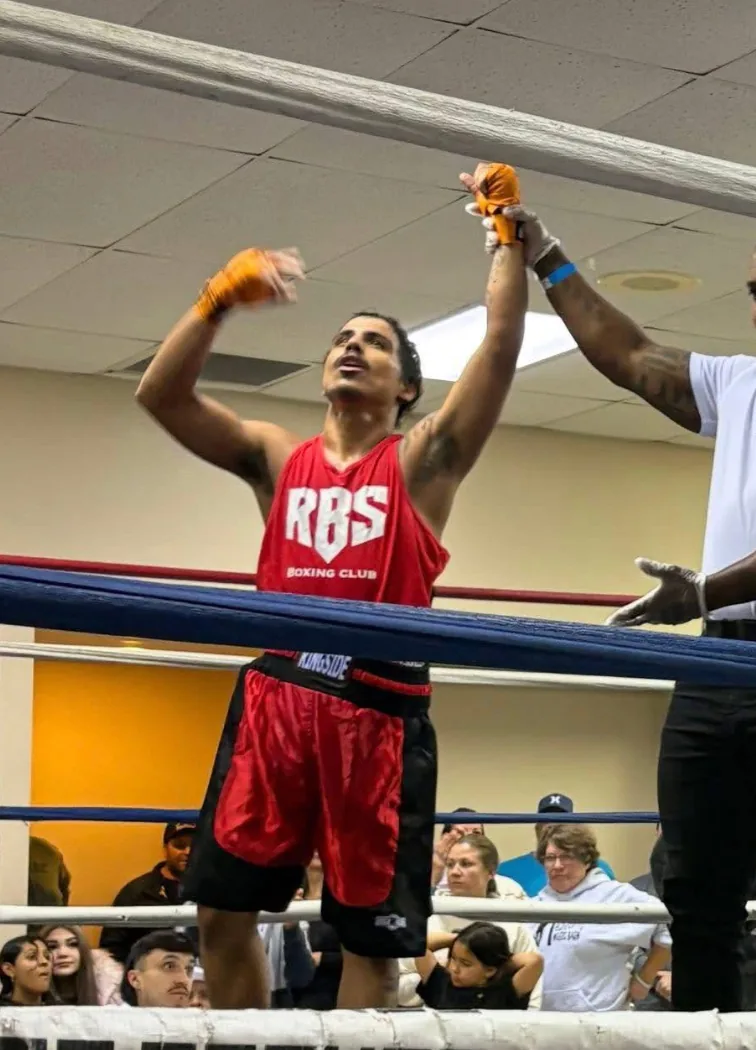 RBS athlete's hand raised in victory at a boxing event